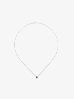 Colgante de oro blanco de 18K con zafiro azul en talla brillante de 0,23 cts y orla de 10 diamantes en talla brillante con un total de 0,07 cts