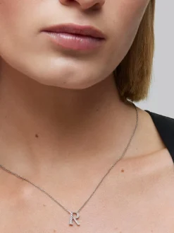 Colgante de oro blanco de 18K con letra R y 14 diamantes en talla brillante con un total de 0,07 cts