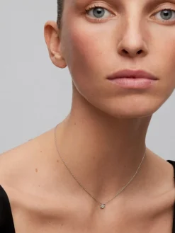Colgante de oro blanco de 18K con diamante central en talla brillante de 0,1 cts y 12 diamantes en talla brillante con un total de 0,15 cts
