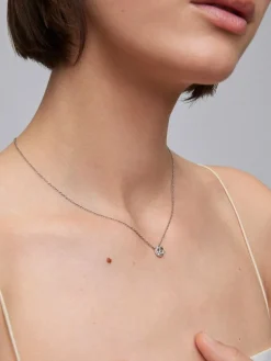 Colgante de oro blanco de 18K con una amatista verde en talla brillante de 0,44 cts y 12 diamantes en talla brillante con un total de 0,13 cts