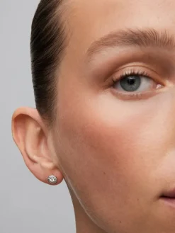 Pendientes de oro blanco de 18K con 2 diamantes centrales en talla brillante con un total de 0,2 cts y orla de 24 diamantes en talla brillante con un total de 0,1 cts