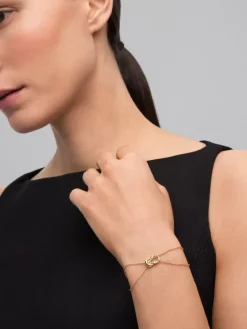 Pulsera de oro amarillo de 18K con 17 diamantes en talla brillante con un total de 0,15 cts y forma de nudo