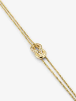 Pulsera de oro amarillo de 18K con 17 diamantes en talla brillante con un total de 0,15 cts y forma de nudo