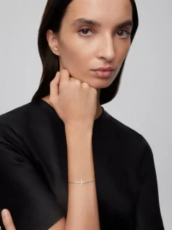 Pulsera de oro blanco de 18K con cruz de diamantes en talla brillante de 0,17 cts