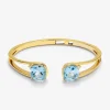 Pulsera r&iacute;gida de oro amarillo de 18K con 2 topacios azul sky en talla cushion con un total de 0,12 cts