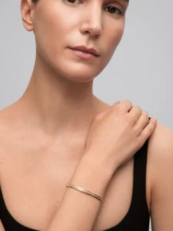 Pulsera r&iacute;gida de oro amarillo de 18K con 64 diamantes en talla brillante con un total de 0,38 cts