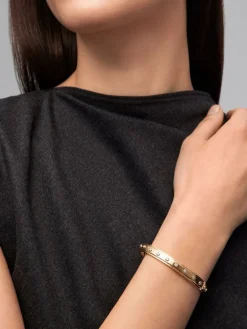 Pulsera r&iacute;gida de oro amarillo de 18K con 11 diamantes en talla brillante con un total de 0,36 cts