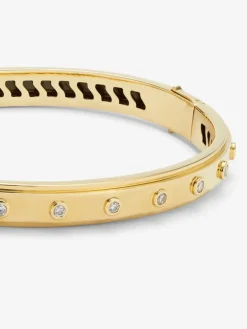 Pulsera r&iacute;gida de oro amarillo de 18K con 11 diamantes en talla brillante con un total de 0,36 cts