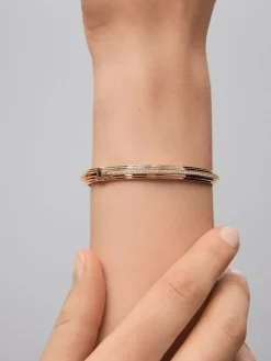 Pulsera r&iacute;gida de oro amarillo de 18K con 69 diamantes en talla brillante con un total de 0,42 cts