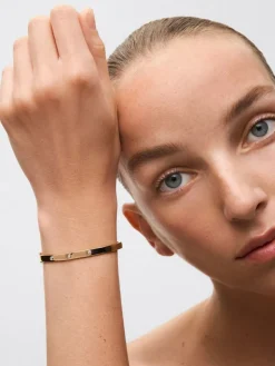 Pulsera r&iacute;gida de oro amarillo de 18K con diamantes blancos en talla brillante de 0,13 cts