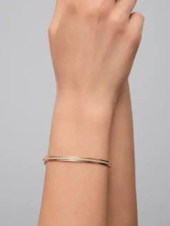 Pulsera r&iacute;gida de oro amarillo de 18K con 64 diamantes en talla brillante con un total de 0,38 cts