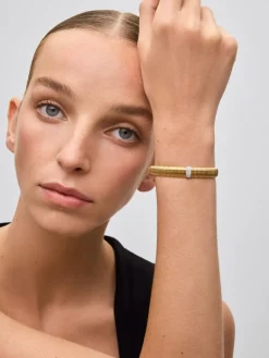 Pulsera r&iacute;gida gallonada de oro blanco y amarillo de 18K con pavé de diamantes en talla brillante con un total de 0,16 cts