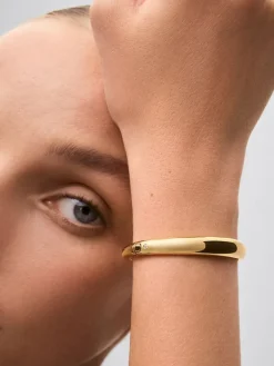 Pulsera r&iacute;gida lisa de oro amarillo de 18K con diamante